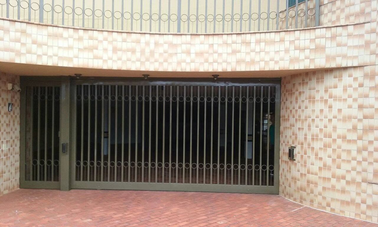 Portão residencial com barras verticais e detalhes circulares da Pimentel Portões